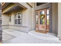 House entrance with wooden door and welcome mat at 6297 Ellingwood Point Way, Castle Rock, CO 80108