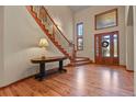 Elegant entryway with hardwood floors, curved staircase, and large windows at 6297 Ellingwood Point Way, Castle Rock, CO 80108