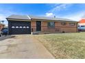 Charming brick ranch home with attached garage and landscaped front yard at 7001 Warren Dr, Denver, CO 80221