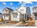 Two-story modern farmhouse with white brick exterior, wooden fence, and landscaped yard at 3316 N Coolidge Way, Aurora, CO 80019