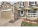 Front entrance of the house with stone accents and a white door at 5363 E Weston Ave, Castle Rock, CO 80104