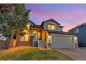 Evening view of a two story home with landscaping and two car garage at 17166 Yellow Rose Way, Parker, CO 80134