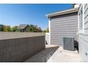 Private patio with gray siding and AC unit at 14300 Waterside Ln # L5, Broomfield, CO 80023