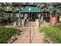 Inviting entrance to the lodge with stone steps and green awning at 27425 Spruce Ln, Evergreen, CO 80439