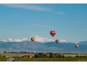 Hot air balloons over scenic mountain views and a park at 604 Twilight St, Erie, CO 80516