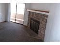 Living room with stone fireplace and access to patio at 12043 W Cross Dr # 201, Littleton, CO 80127