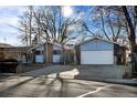 Two-car garage and front yard view of a ranch-style home with mature trees at 1151 S Nome St, Aurora, CO 80012