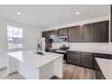 Modern kitchen with island and stainless steel appliances at 10960 Norfolk Ct, Commerce City, CO 80022