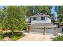 Two-story house with gray siding, brick accents, and a two-car garage at 1450 E 128Th Ct, Thornton, CO 80241