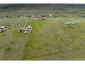 Wide aerial view of a large property with multiple buildings and open fields at 12155 Mesa View Rd, Larkspur, CO 80118