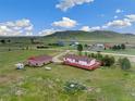 Aerial view of a home with a large yard, outbuildings, and distant mountains at 12155 Mesa View Rd, Larkspur, CO 80118