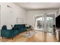 Living room with hardwood floors, comfy seating, and access to balcony at 15195 E 16Th Pl # 204, Aurora, CO 80011
