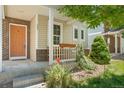 Covered porch with orange door and wooden bench at 10700 Kimblewyck Cir # 159, Northglenn, CO 80233