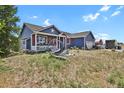 Blue house with red accents and porch swing at 3188 S County Road 137, Bennett, CO 80102