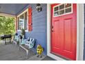Front porch with red door and metal chicken decor at 3188 S County Road 137, Bennett, CO 80102