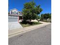 Two-story home with gray siding, brick accents, and a two-car garage at 6043 S Waco St, Aurora, CO 80016