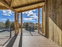 Covered deck with wooden beams and railings, overlooking the neighborhood and distant mountains at 3534 Running Deer Dr, Castle Rock, CO 80109