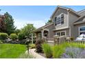 Townhome exterior showcasing a charming stone and siding design with lush landscaping at 7371 Norfolk Pl, Castle Pines, CO 80108