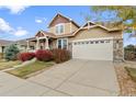 Two-story house with beige siding, a large garage, and landscaping at 6470 S Ider St, Aurora, CO 80016