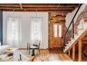 Bright entryway with exposed brick, wood floors, and wooden door at 2731 California St, Denver, CO 80205