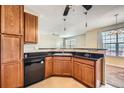 Kitchen with dark wood cabinets, granite countertops, and black appliances at 9142 Lodestar Ln # 207, Parker, CO 80134