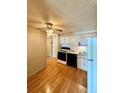 Kitchen with wood cabinets, laminate flooring, and a view into the dining area at 1302 S Parker Rd # 226, Denver, CO 80231