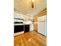 Bright kitchen featuring wood cabinets, laminate flooring, and modern appliances at 1302 S Parker Rd # 226, Denver, CO 80231