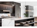 Modern kitchen with dark cabinetry, marble countertops, and an island with seating at 3167 W 26Th Ave, Denver, CO 80211