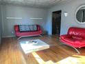 Bright living room with hardwood floors and red leather seating at 7625 W 23Rd Pl, Lakewood, CO 80214