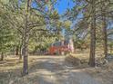 Red barn-style home nestled in trees at 1300 Main St, Georgetown, CO 80444