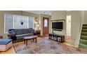 Living room with hardwood floors, comfortable seating, and patterned rug at 562 S Xenon Ct, Lakewood, CO 80228