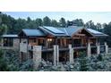 Stunning stone house with metal roof, expansive deck, and mountain views at 7474 Spring Drive, Boulder, CO 80303