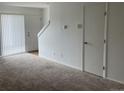 Living room features carpeted floors, a door, and a view of a staircase at 912 S Peoria St, Aurora, CO 80012