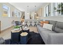 Open living area with light hardwood floors, gray sofa, and kitchen island at 1411 Zenobia St, Denver, CO 80204