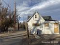 Side view of a white house needing repairs; located on a quiet street at 4118 W 1St Ave, Denver, CO 80219