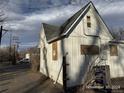 Rear view of a white house needing repairs; located on a quiet street at 4118 W 1St Ave, Denver, CO 80219