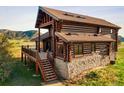 Log cabin home with stone foundation, deck, and mountain views at 11067 Spruce Mountain Rd, Larkspur, CO 80118