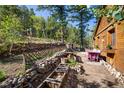 Charming patio area with stone wall, flowers, and wooden bench at 80 Outlook Dr, Golden, CO 80403