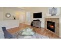 Living room featuring hardwood floors, fireplace, and ample natural light at 6656 S Shawnee St, Aurora, CO 80016