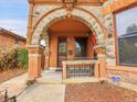 Front porch with stone archway, ornate iron railing, and a charming entryway at 3611-3615 Osage St, Denver, CO 80211
