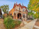 Victorian-style home with unique stonework, arched entryways, and beautiful landscaping at 3611-3615 Osage St, Denver, CO 80211