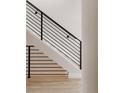 Modern staircase with black metal railing and light wood steps at 3302 N Lafayette St, Denver, CO 80205