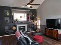 Living room with a fireplace, built-in shelves, and hardwood floors at 13403 Gaylord St, Thornton, CO 80241