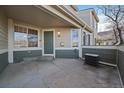 Front entry of townhome with covered porch and green door at 930 Button Rock Dr # J59, Longmont, CO 80504