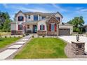 Two-story home with stone accents and red shutters at 15 Latigo Pl, Littleton, CO 80123