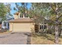Two-story house with beige siding, attached garage, and landscaping at 24087 Deer Valley Rd, Golden, CO 80401