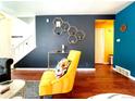 Bright living room with yellow armchair, geometric shelves, and hardwood floors at 10330 W Jewell Ave # A, Lakewood, CO 80232