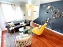 Living room with dark gray couch, yellow armchair, and wood floors at 10330 W Jewell Ave # A, Lakewood, CO 80232