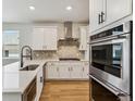 Modern kitchen with white cabinets and stainless steel appliances at 42996 Colonial Trl, Elizabeth, CO 80107