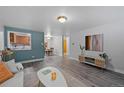 Open living room featuring hardwood floors and a view into the kitchen at 1260 York St # 105, Denver, CO 80206
